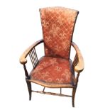 An art nouveau armchair, the tapering upholstered back with brass studding above rounded arms on