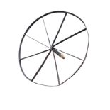 A circular garden table in the form of a wrought iron spoked wheel, attached to an axel for