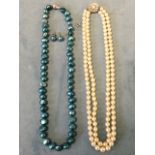 A twin pearl choker necklace, each strand with over 70 knotted pearls with flowerhead clasp; and a