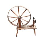 A nineteenth century oak spinning wheel with wide flat rim and turned spindles on rectangular