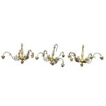 A set of three hanging brass chandeliers, each with baluster type columns above bun shaped bosses