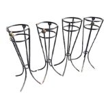 A set of four circular wrought iron stands on four twisted waisted legs, the rails mounted with