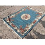An Axminster style rug woven with circular floral medallion on pale blue field framed by