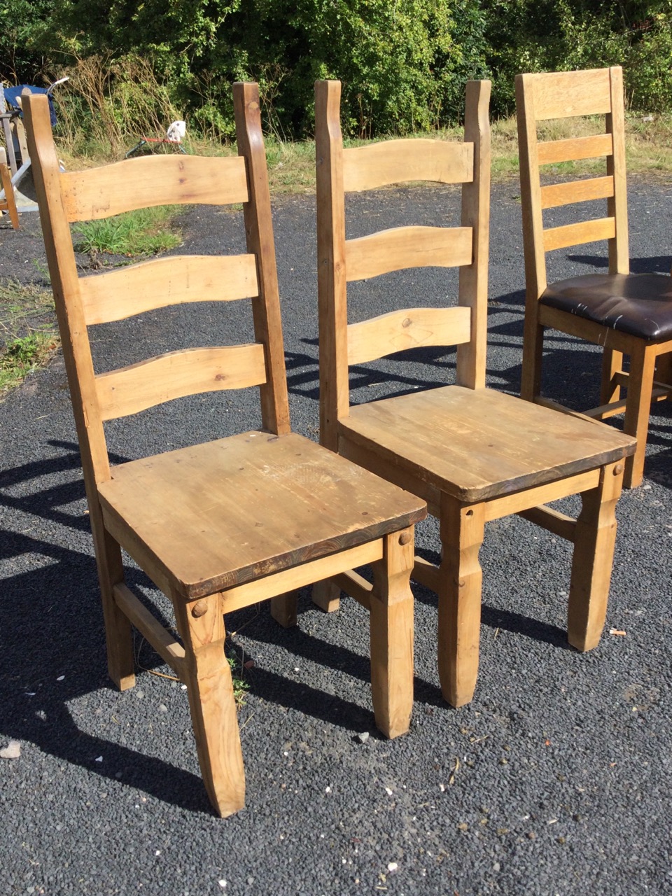 A pair of pine ladderback chairs with long plank seats on square shaped column legs joined by - Bild 2 aus 3
