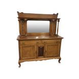 A late Victorian mahogany sideboard, the carved back with shaped bevelled mirror beneath a moulded