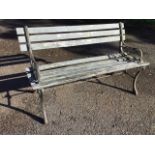 A rectangular 4ft garden bench with slatted back and seat on cast iron supports, with pierced