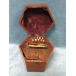 A mahogany cased Victorian hexagonal rosewood concertina, the bellows with leather borders, and