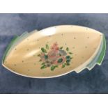 An elliptical Clarice Cliff bowl painted with flowers on lemon ground, the rim modelled with fins
