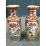 A pair of tubular Chinese famile rose vases decorated with oval panels of birds in gardens with