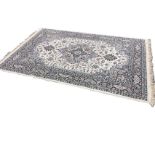 An oriental style rug woven with central floral medallion and pendants on grey field with linked