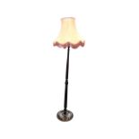 A stained standard lamp with turned column on circular base with three bun feet, mounted with