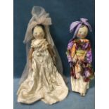 A pair of nineteenth century wood dolls with painted heads and peg jointed bodies, one dressed as