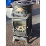 A Provence gas heater with tubular cabinet and faux logs behind glass door, mounted on stand with