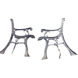 A pair of cast iron bench ends with scrolled decoration, raised on channelled sabre legs. (2)