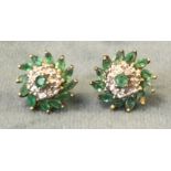 A pair of emerald and diamond ear studs of flowerhead form framed by border of leaf shaped emeralds,