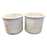 A pair of tubular stoneware garden pots with moulded rims, the exteriors in roughcast finish