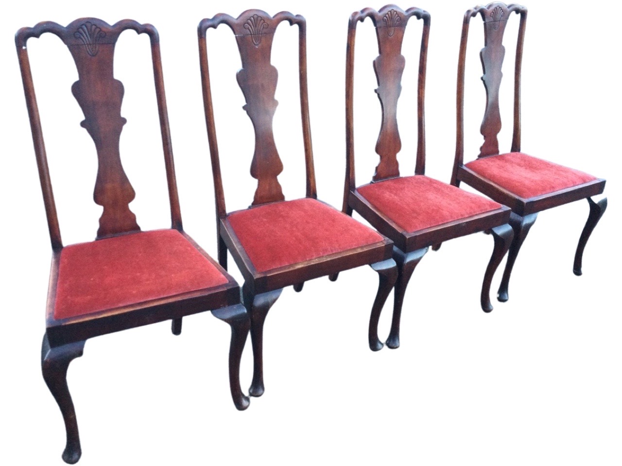 A set of four Edwardian stained Queen Anne style dining chairs, the shaped splats with shell carving