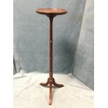 A mahogany jardiniere stand with circular tray top on tapering ring-turned column, above ribbed