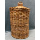 A large cane laundry basket with twisted rim and hat shaped cover with handle. (32in)
