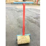 A painted metal garden roller with concrete drum. (51in)