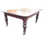 A large 10/12 seater Victorian mahogany dining table, the extending top with spare leaf supported on