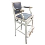 A painted high chair with leather stud upholstered back and seat, the splayed arms with elbow