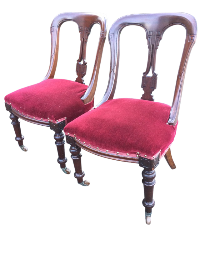 A pair of late Victorian mahogany dining chairs with shaped moulded backs framing pierced splats,