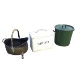 A helmet shaped brass coal scuttle with swing handle on paw feet; a rectangular enamelled breadbin