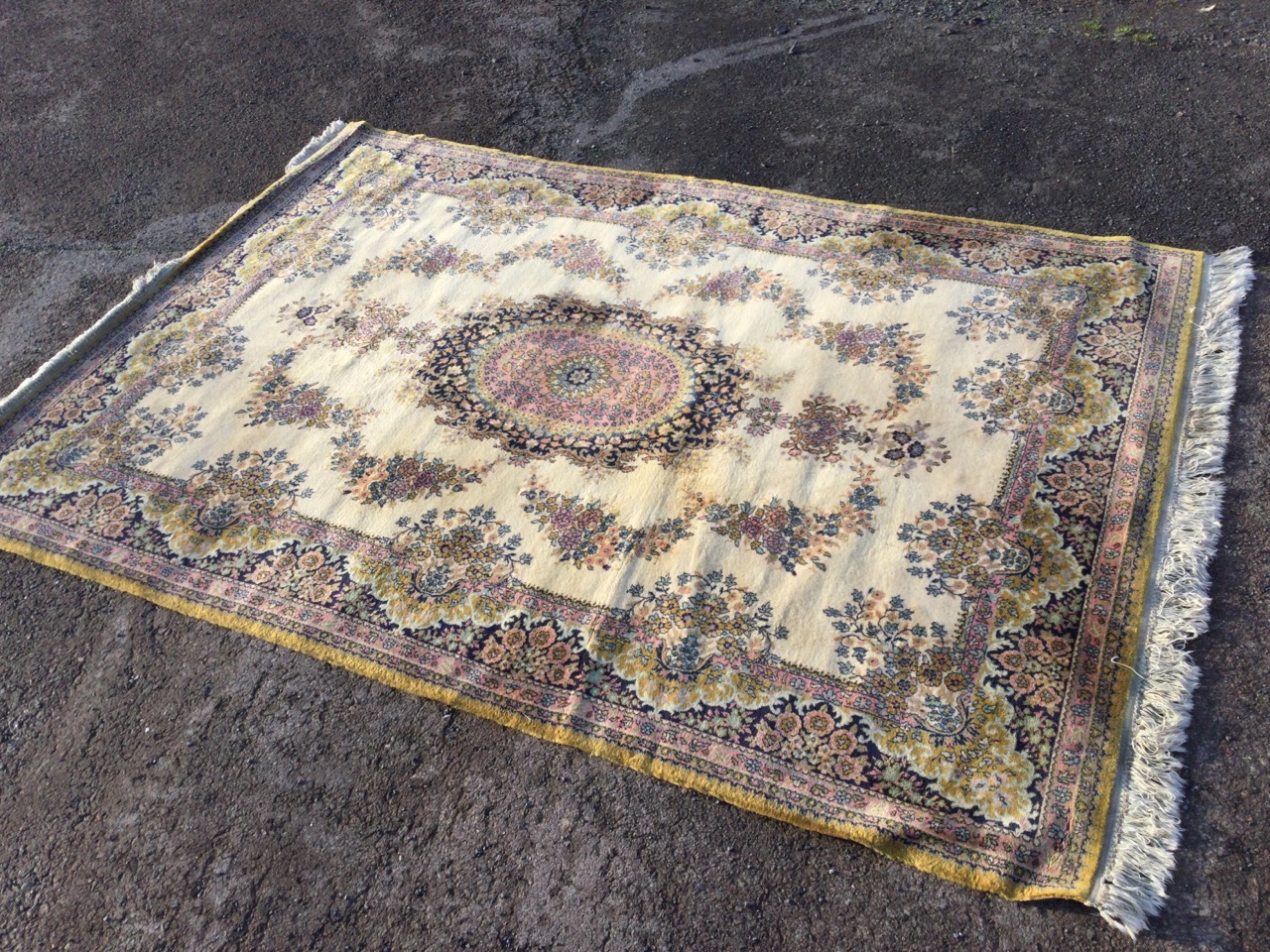 An Axminster rug woven in the oriental manner with oval floral medallion framed by garlands on