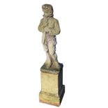 A composition stone statue of a young gentleman, the coated figure standing by treetrunk on
