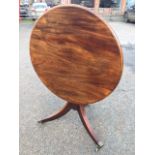 A circular mahogany snap-top occasional table, raised on turned column with tripartite tapering