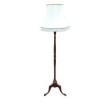 A mahogany standard lamp with octagonal fabric shade on turned column, with tripartite legs and