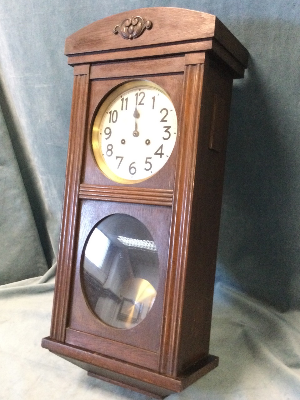 A 30s oak cased Vienna style wallclock with arched top above a moulded framed door, enclosing a