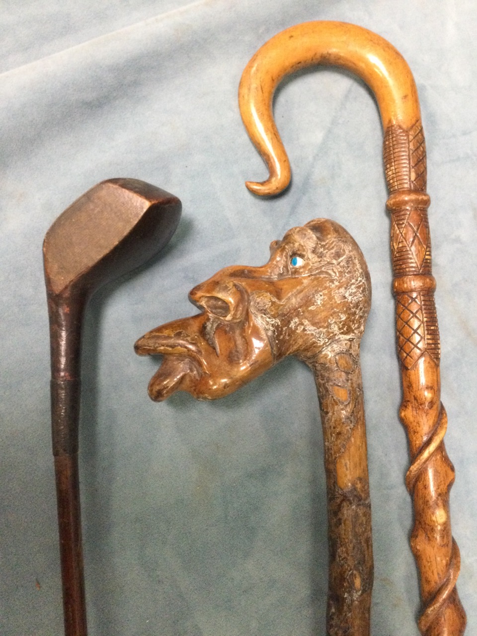 A carved and twisted stick with scrolled crook style handle; a Victorian golf club with wood shaft