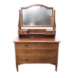 An Edwardian mahogany dressing table inlaid with chequered banding, the arched bevelled mirror above