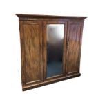 A Victorian mahogany wardrobe with moulded cornice above a central mirror door flanked by panelled