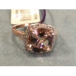 A 14ct rose gold ring set with a facet cut morganite framed by border of 32 small diamonds, the