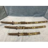 A set of three graduated Japanese style swords with shaped steel blades in dragon gilt cloth mounted