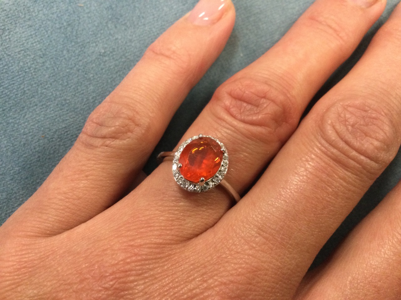 A platinum fire opal ring, the claw set oval Salamanca fire opal framed by border of small diamonds, - Image 3 of 3