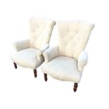 A pair of button upholstered chairs with tapering backs and rounded arms above sprung seats,