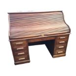 A late Victorian mahogany roll-top desk, the tambour enclosing a fitted interior of small drawers