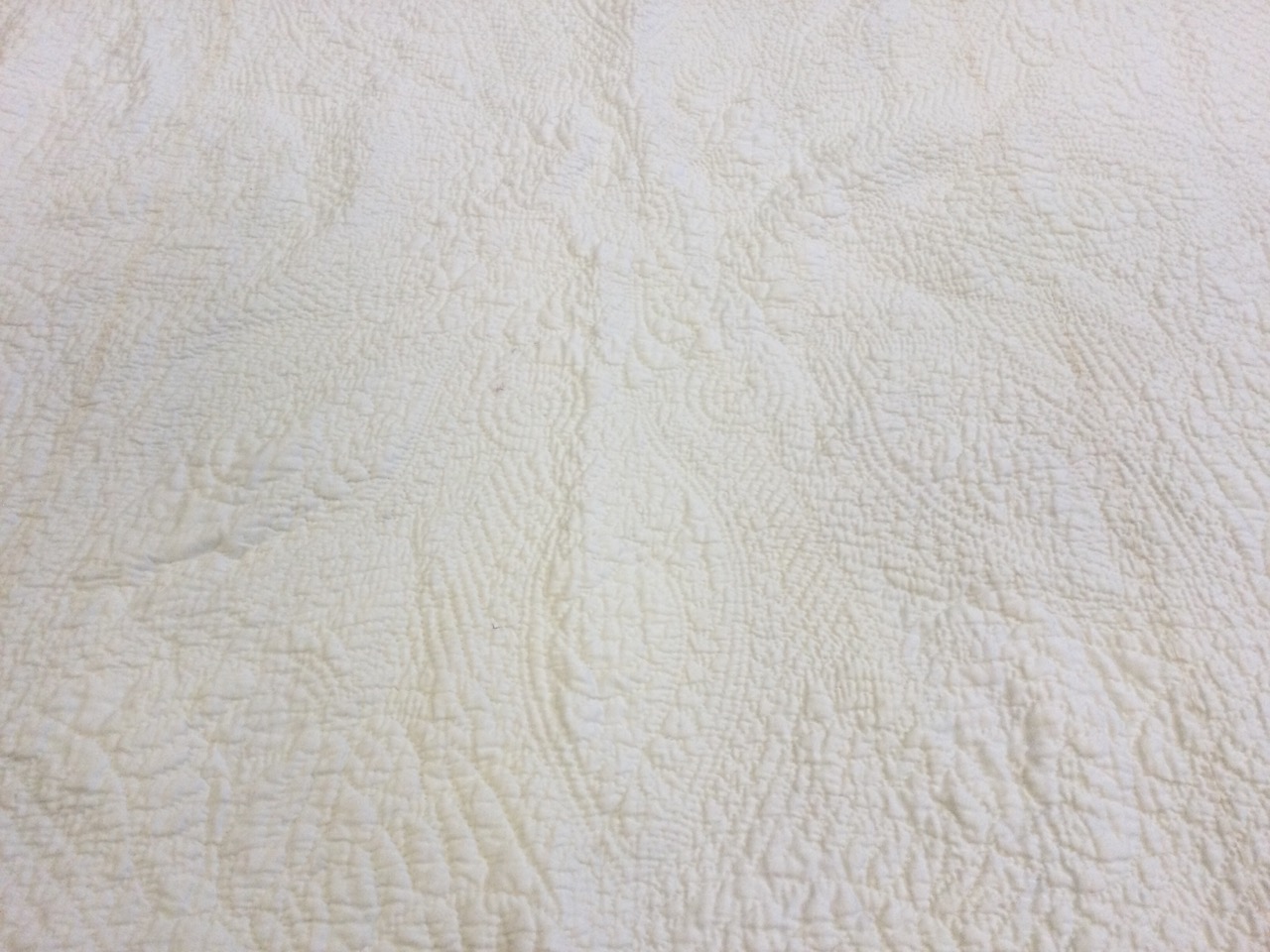 A large white cotton Durham quilt, hand-sewn in an embossed floral quilted pattern. (78in x 104in) - Image 2 of 3