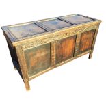 A nineteenth century dowel jointed carved oak coffer with three panels to hinged lid and front