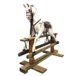 An old painted wood rocking horse with leather tack & saddle and horsehair mane, the animal on