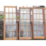 A set of 20 hardwood glazed doors, each with fifteen panes in moulded panels, fitted with iron