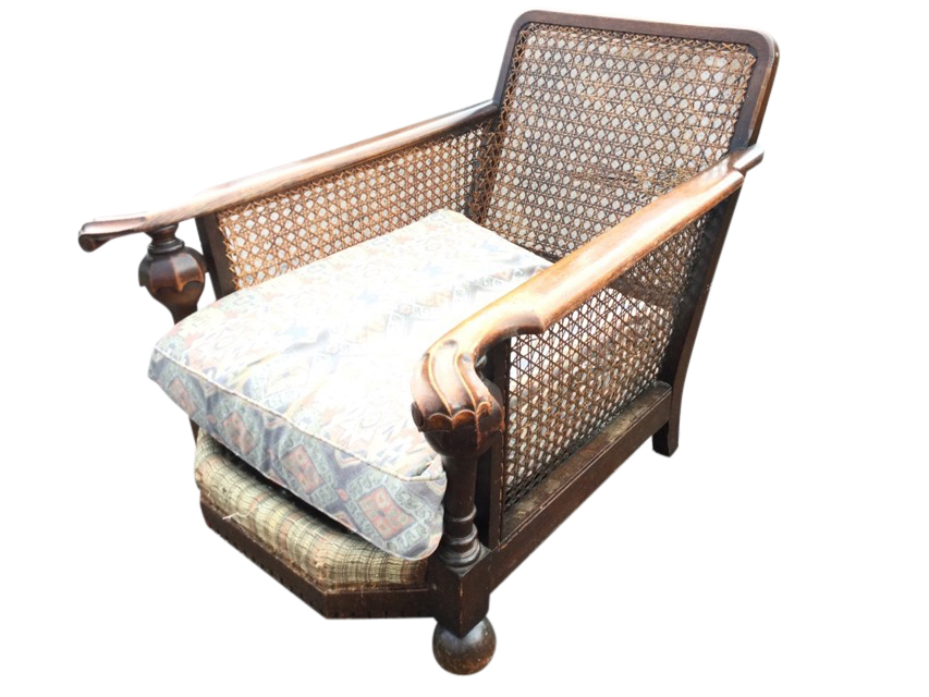 An oak begere armchair with cane back & sides having scroll carved platform arms supported on