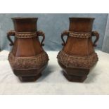 A pair of hexagonal Japanese bronze vases embossed with stylised scrolled friezes on greek key