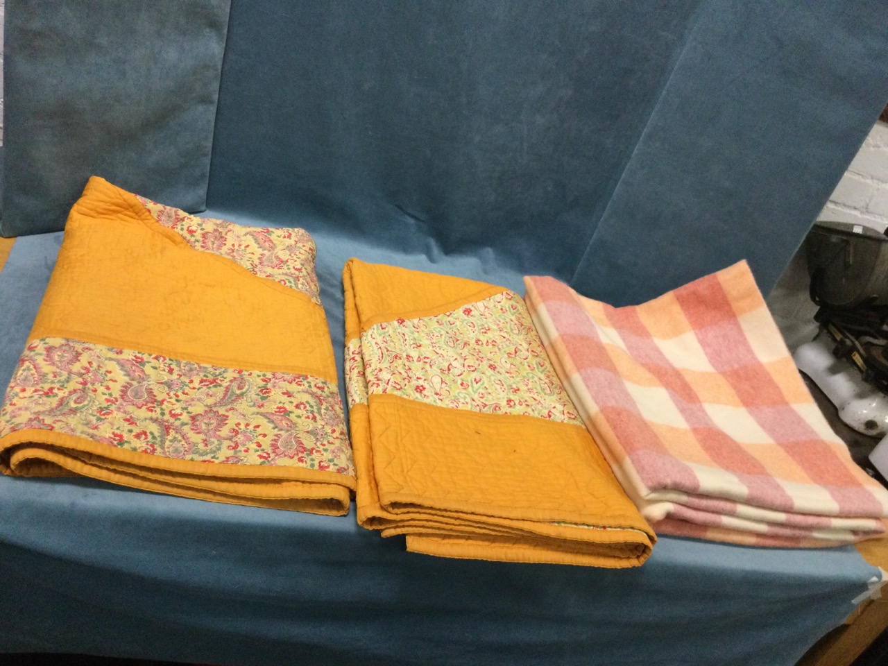 A pair of rectangular C20th cotton quilts sewn with paisley printed panels and borders on orange