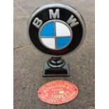 An oval painted cast iron engine sign; and a BMW alloy sign with circular logo on plinth. (2)