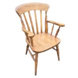 A lathe-back farmhouse armchair with shaped arms on spindles above a solid seat, raised on turned